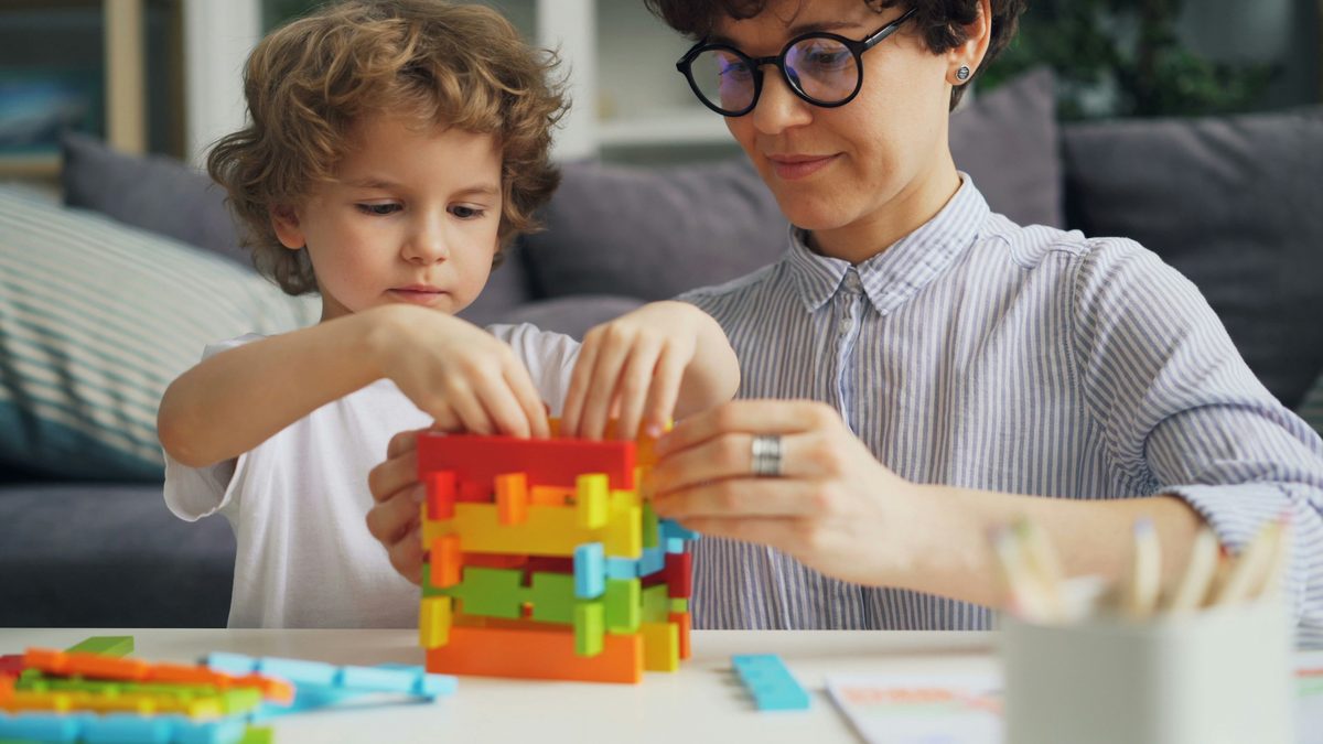 Caregiver and child building together